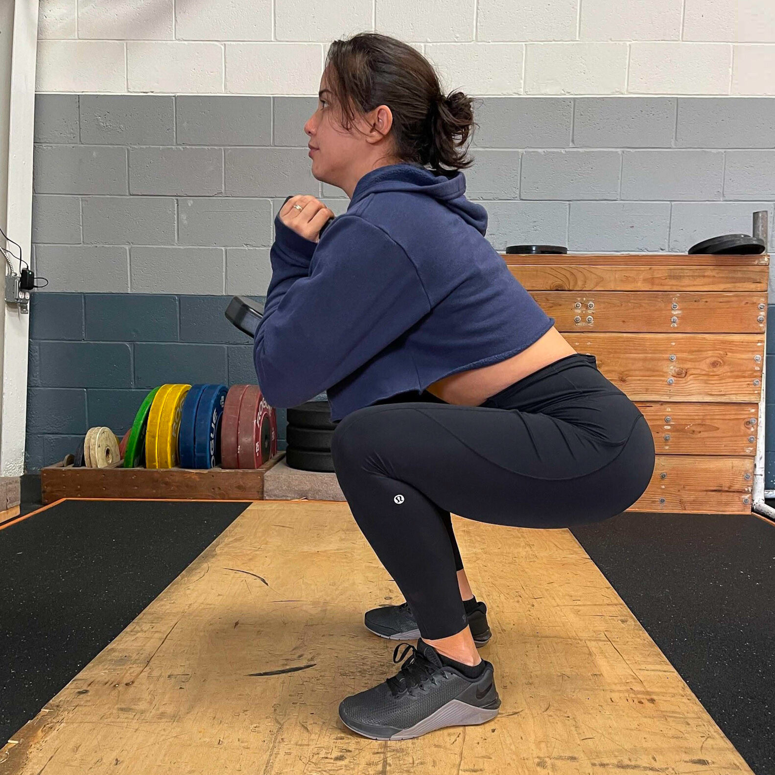 Young woman squatting with weight held at her chest